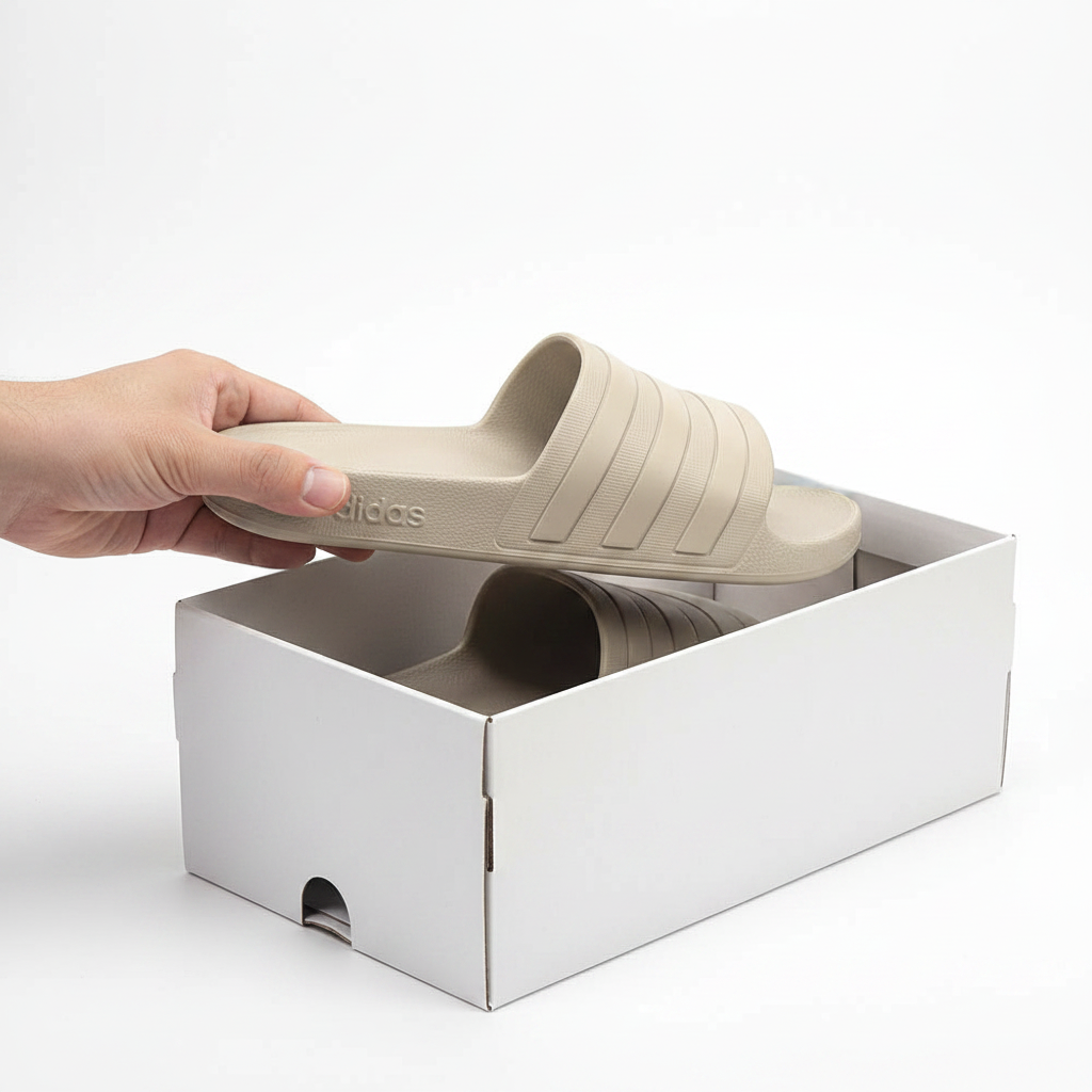 Adidas Adilette Aqua IE1456 beige – mains sortant la claquette de la boîte Adidas-birdnova-algerie
