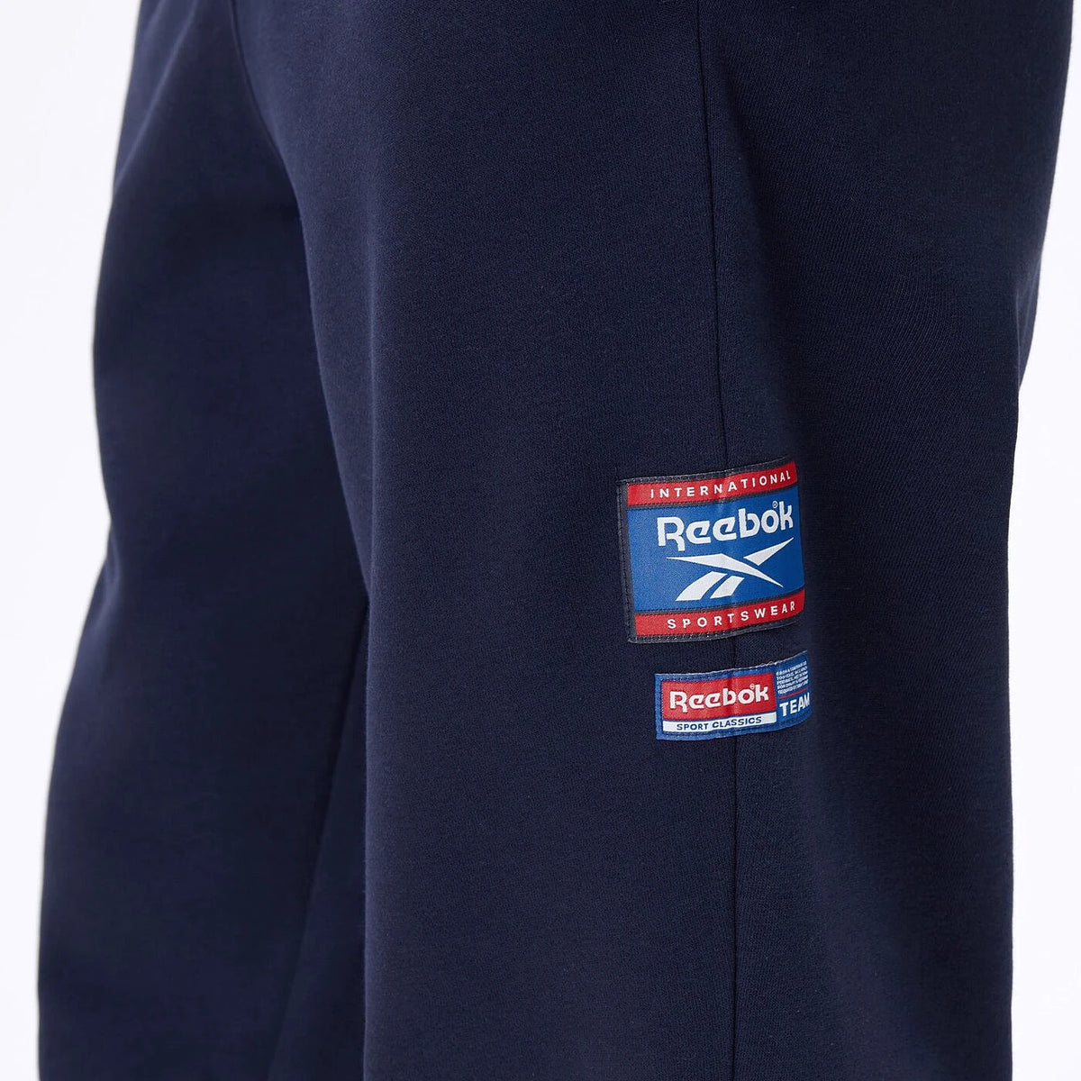 Étiquette tissée Reebok sur la cuisse du jogging bleu marine — original BirdNova Algérie