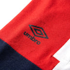 Umbro Polo Colorblock — logo double diamant sur bloc rouge, original BirdNova Algérie