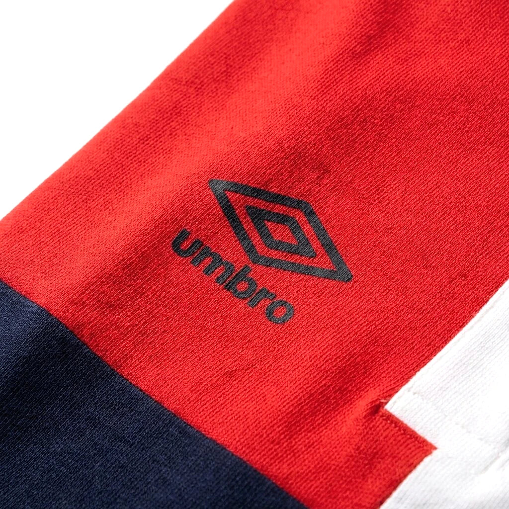Umbro Polo Colorblock — logo double diamant sur bloc rouge, original BirdNova Algérie