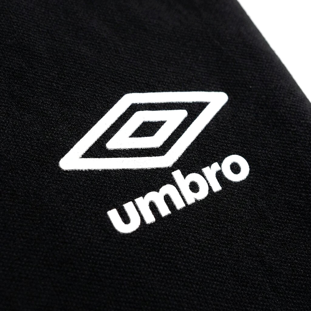 Logo Umbro losange blanc sur panneau noir du polo vert — original BirdNova Algérie